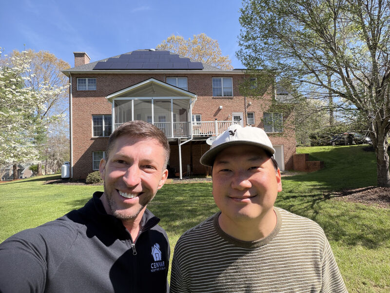 Solar consultant with customer in front of large residential solar installation